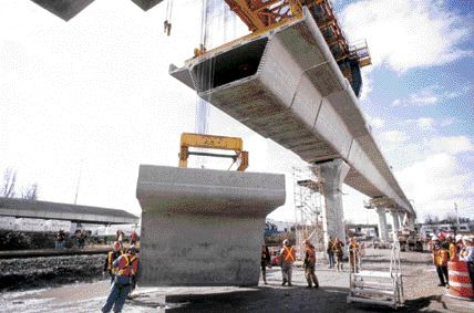 Erecting a precast concrete guideway beam segment; 50 tonnes of concrete was used to buld an average support column.
