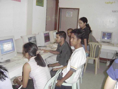 Raisinghani (centre, wearing a dark shirt) training Filipinos in computer skills, so that they can become trainers themselves.