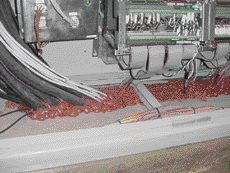 Fire-resistant foam forms the firestop around wires in a floor.