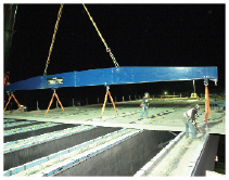 Setting full-width, 19-m wide precast deck panels at night.